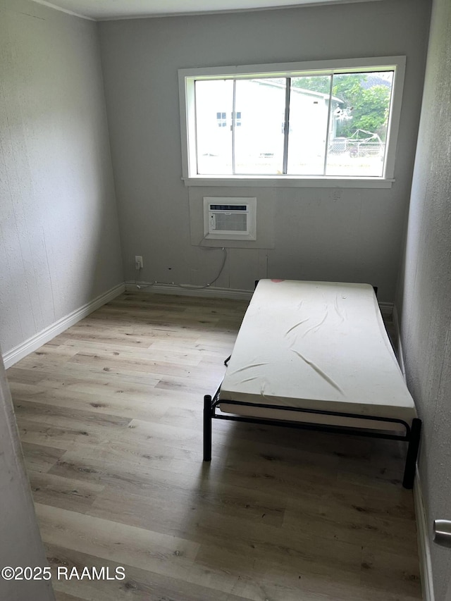 113 Fred St, Lafayette, LA 70501 - unfurnished bedroom with wood finished floors, an AC wall unit, and baseboards