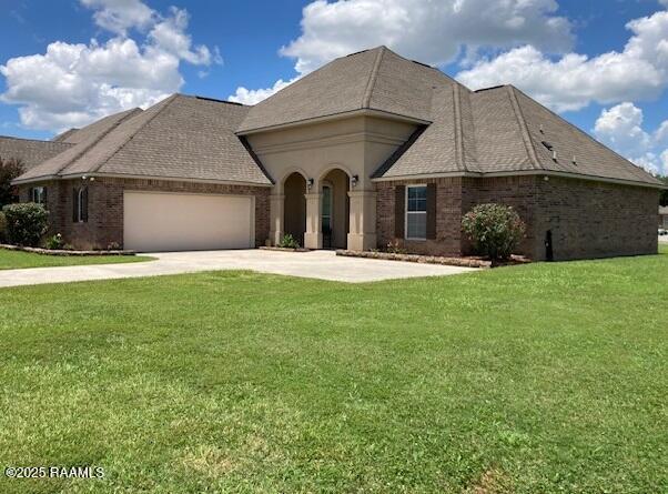 123 Angel Rock Ln, Broussard, LA 70518 - french country inspired facade with concrete driveway, a garage, a front yard, and brick siding