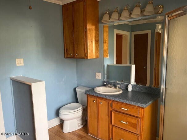 201 Allen St, New Iberia, LA 70563 - bathroom with toilet, wood finished floors, vanity, and baseboards