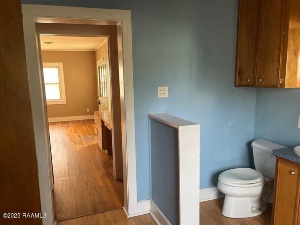 201 Allen St, New Iberia, LA 70563 - bathroom with wood finished floors, baseboards, toilet, vanity, and crown molding