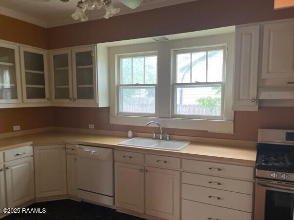 201 Allen St, New Iberia, LA 70563 - kitchen featuring dishwasher, range, a sink, light countertops, and white cabinets