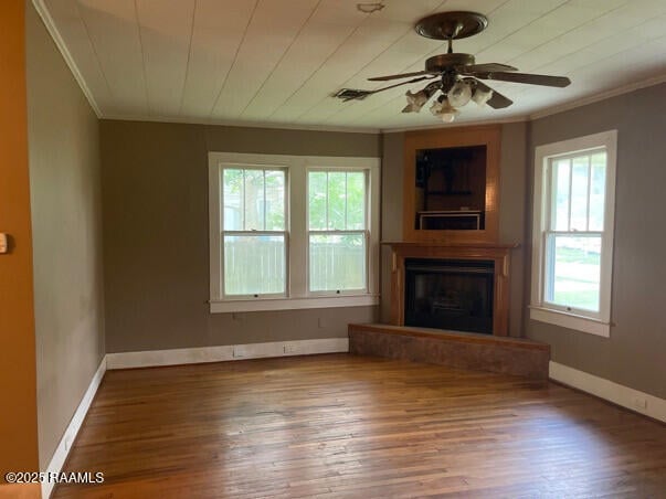 201 Allen St, New Iberia, LA 70563 - unfurnished living room with ornamental molding, a fireplace with raised hearth, ceiling fan, hardwood / wood-style floors, and baseboards
