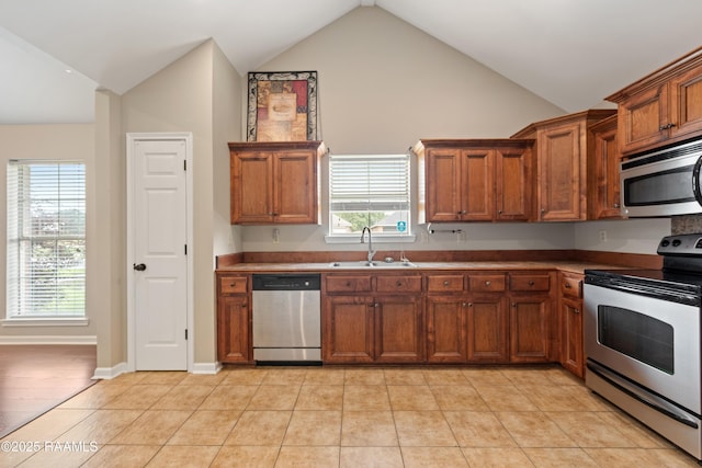 320 Golden Grain, Duson, LA 70529 - kitchen featuring appliances with stainless steel finishes, a sink, brown cabinets, plenty of natural light, and high vaulted ceiling