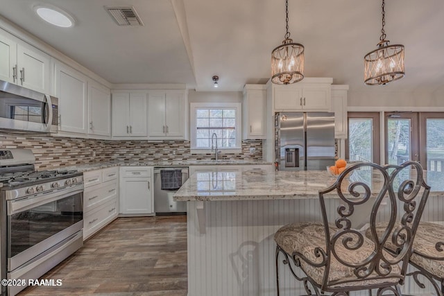 115 Hiawatha Rd, Lafayette, LA 70501 - kitchen featuring appliances with stainless steel finishes, a kitchen bar, a chandelier, a sink, and backsplash