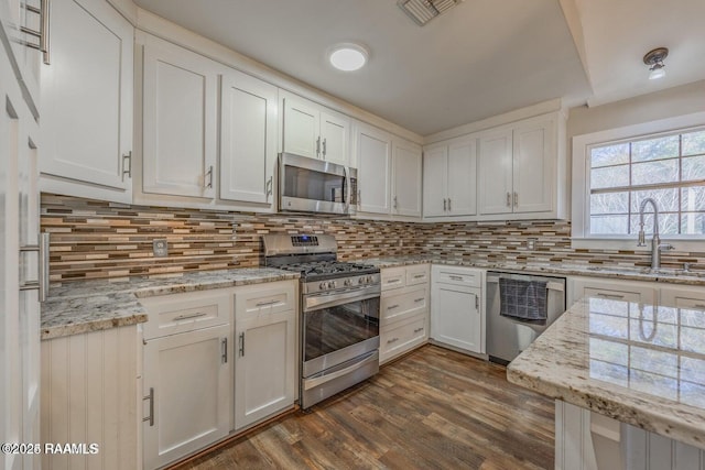 115 Hiawatha Rd, Lafayette, LA 70501 - kitchen with stainless steel appliances, a sink, white cabinetry, and decorative backsplash