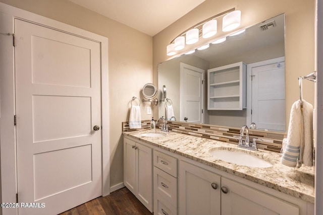 115 Hiawatha Rd, Lafayette, LA 70501 - bathroom with double vanity, wood finished floors, and decorative backsplash