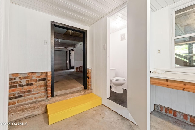 4802 Lafitte St, New Iberia, LA 70560 - bathroom featuring concrete flooring, toilet, and wood walls