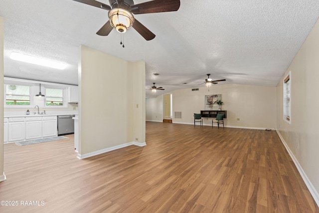 4802 Lafitte St, New Iberia, LA 70560 - unfurnished living room with a sink, a textured ceiling, ceiling fan, light wood-style floors, and baseboards
