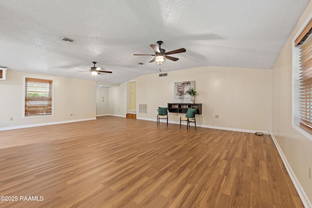 4802 Lafitte St, New Iberia, LA 70560 - unfurnished living room featuring a textured ceiling, a ceiling fan, light wood-type flooring, baseboards, and lofted ceiling