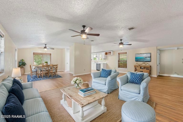 4802 Lafitte St, New Iberia, LA 70560 - living area with light wood finished floors, a textured ceiling, a ceiling fan, and baseboards