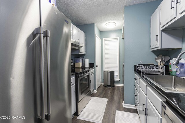 16 Heather Row, Lafayette, LA 70507 - kitchen featuring appliances with stainless steel finishes, dark countertops, dark wood-type flooring, white cabinets, and a textured ceiling