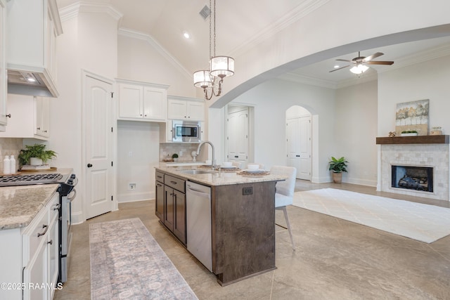203 Sanctuary Ln, Lafayette, LA 70503 - kitchen featuring stainless steel appliances, a sink, arched walkways, white cabinetry, and a ceiling fan