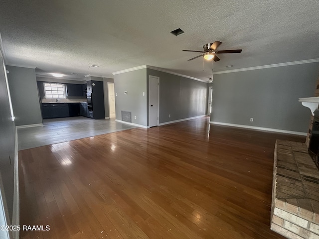106 Dove Cir, Lafayette, LA 70508 - unfurnished living room featuring a textured ceiling, ornamental molding, ceiling fan, hardwood / wood-style flooring, and baseboards