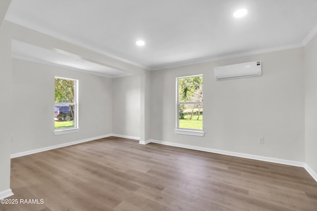 630 Ledoux St, Jennings, LA 70546 - empty room with an AC wall unit, crown molding, healthy amount of natural light, wood finished floors, and baseboards
