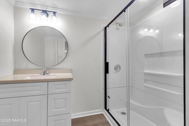 630 Ledoux St, Jennings, LA 70546 - bathroom with a stall shower, vanity, crown molding, baseboards, and wood finished floors