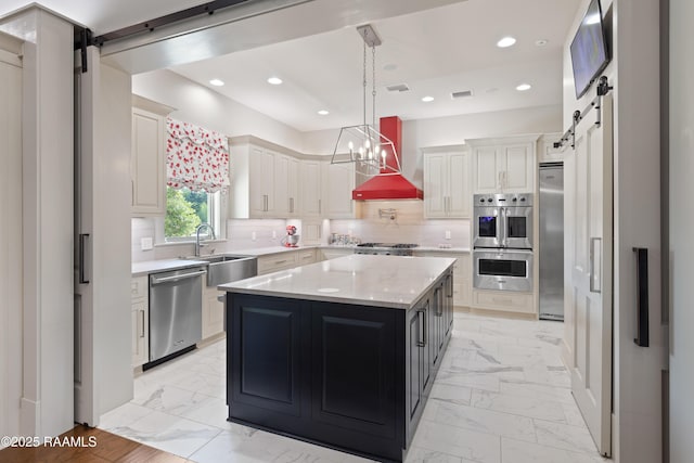 235 N Fieldspan Rd, Scott, LA 70583 - kitchen featuring a barn door, appliances with stainless steel finishes, light marble finish flooring, a sink, and recessed lighting
