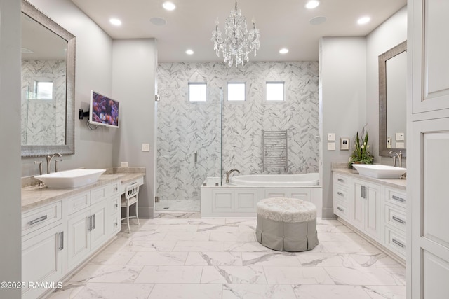 235 N Fieldspan Rd, Scott, LA 70583 - bathroom with marble look tile flooring, a garden tub, two vanities, a shower stall, and a chandelier