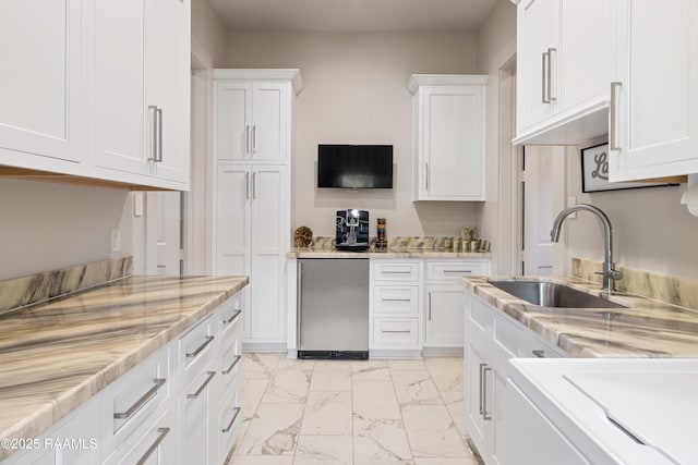 235 N Fieldspan Rd, Scott, LA 70583 - kitchen featuring a sink, light marble finish flooring, white cabinets, and light stone countertops