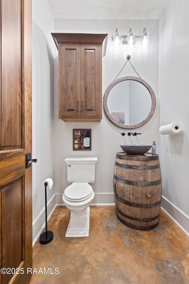 235 N Fieldspan Rd, Scott, LA 70583 - bathroom featuring a sink, toilet, baseboards, and concrete floors