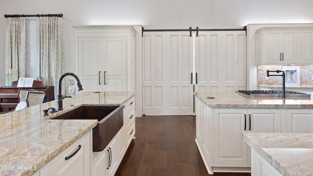 235 N Fieldspan Rd, Scott, LA 70583 - kitchen featuring dark wood finished floors, a sink, light stone countertops, and white cabinets