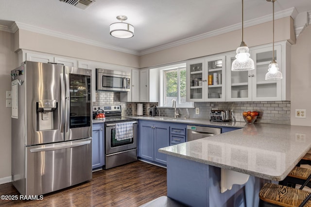 421 Karen Dr, Lafayette, LA 70503 - kitchen featuring appliances with stainless steel finishes, a peninsula, a sink, a breakfast bar, and ornamental molding
