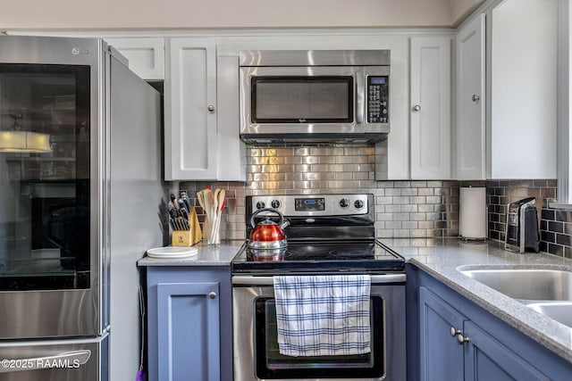 421 Karen Dr, Lafayette, LA 70503 - kitchen featuring stainless steel appliances, blue cabinetry, tasteful backsplash, and white cabinets