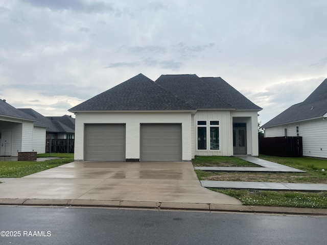 203 Redfern St, Lafayette, LA 70508 - view of front of home featuring driveway, a garage, a shingled roof, and board and batten siding