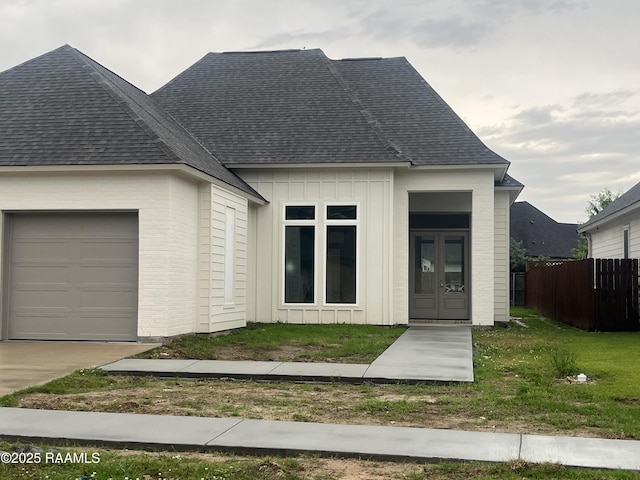 203 Redfern St, Lafayette, LA 70508 - view of front of property with a shingled roof, board and batten siding, an attached garage, brick siding, and driveway