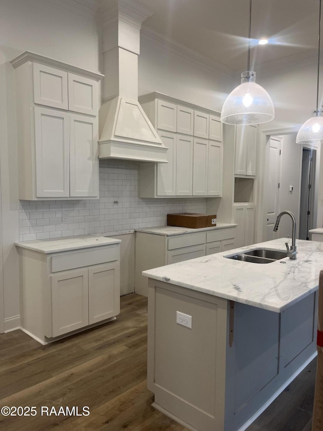 203 Redfern St, Lafayette, LA 70508 - kitchen with a sink, a center island with sink, decorative backsplash, light stone counters, and ornamental molding