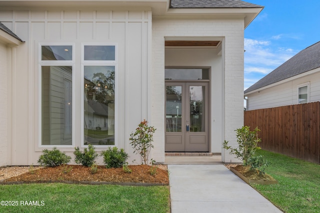 203 Redfern St, Lafayette, LA 70508 - entrance to property featuring board and batten siding, a shingled roof, french doors, and brick siding