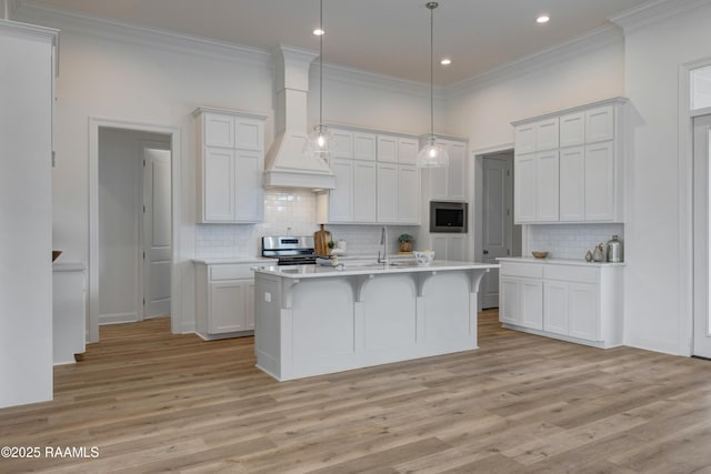 203 Redfern St, Lafayette, LA 70508 - kitchen featuring premium range hood, light countertops, stainless steel appliances, light wood-style flooring, and ornamental molding