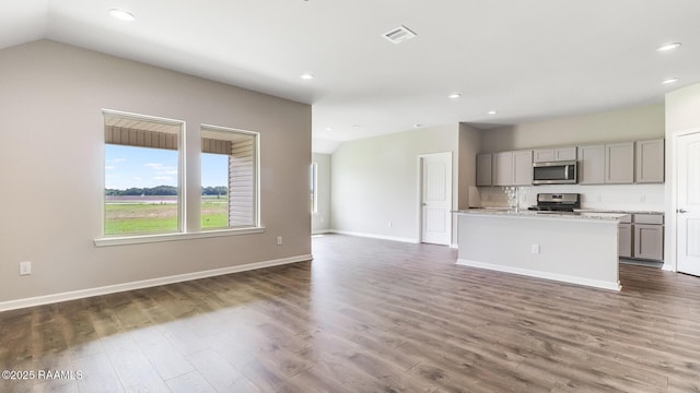 316 White Pine Dr, Lafayette, LA 70501 - kitchen featuring stainless steel microwave, stove, gray cabinetry, vaulted ceiling, and open floor plan