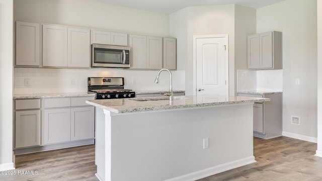 316 White Pine Dr, Lafayette, LA 70501 - kitchen featuring stainless steel appliances, a sink, light wood finished floors, and decorative backsplash