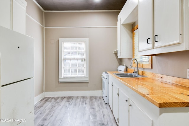 312 Hobson St, Lafayette, LA 70501 - kitchen with freestanding refrigerator, a sink, light wood-style flooring, white cabinetry, and light countertops