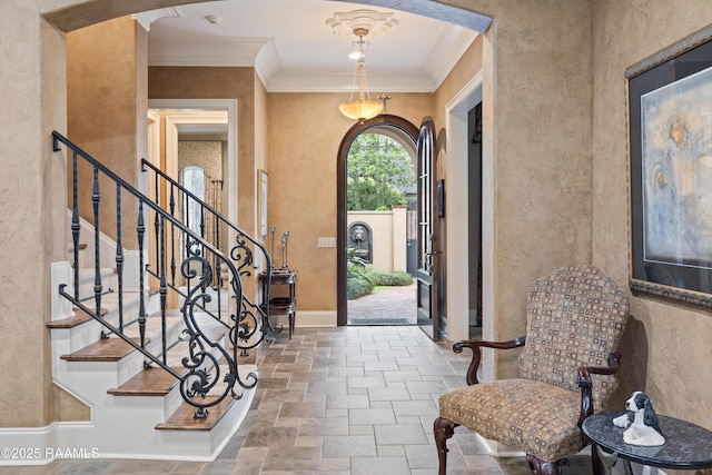 104 Avallach Dr, Lafayette, LA 70503 - foyer featuring stone tile flooring, crown molding, arched walkways, a textured wall, and stairway