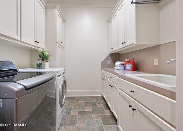 104 Avallach Dr, Lafayette, LA 70503 - laundry room with washing machine and clothes dryer, dark stone finish floors, cabinet space, and baseboards