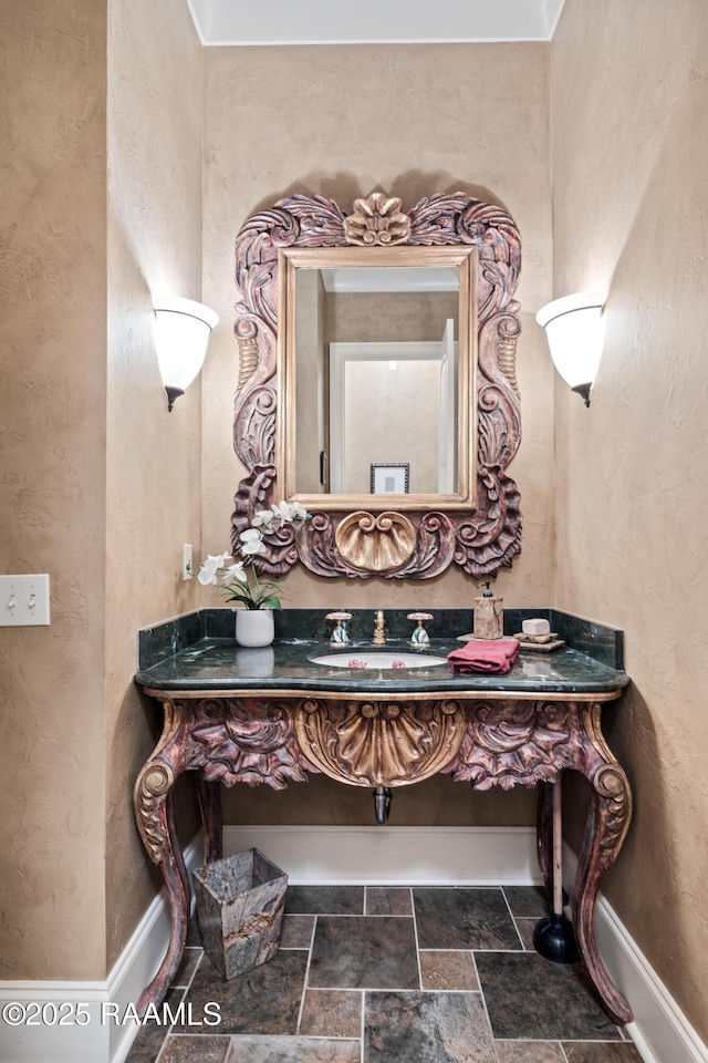 104 Avallach Dr, Lafayette, LA 70503 - bathroom featuring stone finish floors, a textured wall, baseboards, and vanity