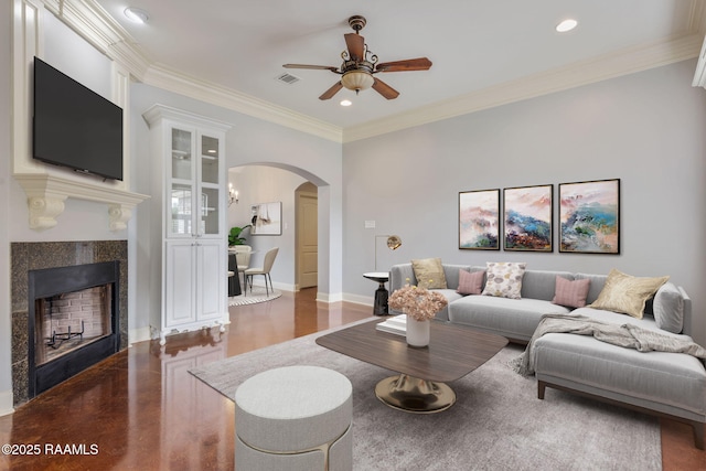 103 Swallows Pass, Carencro, LA 70520 - living room featuring arched walkways, a ceiling fan, a fireplace, wood finished floors, and crown molding