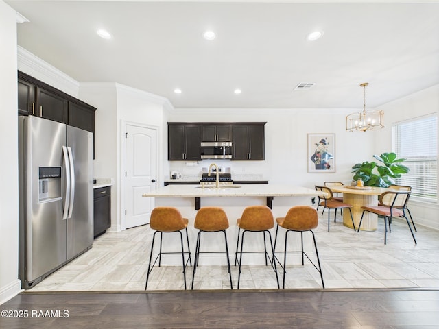 143 Melanie Rose Dr, Maurice, LA 70555 - kitchen with stainless steel appliances, a breakfast bar area, crown molding, a kitchen island with sink, and recessed lighting