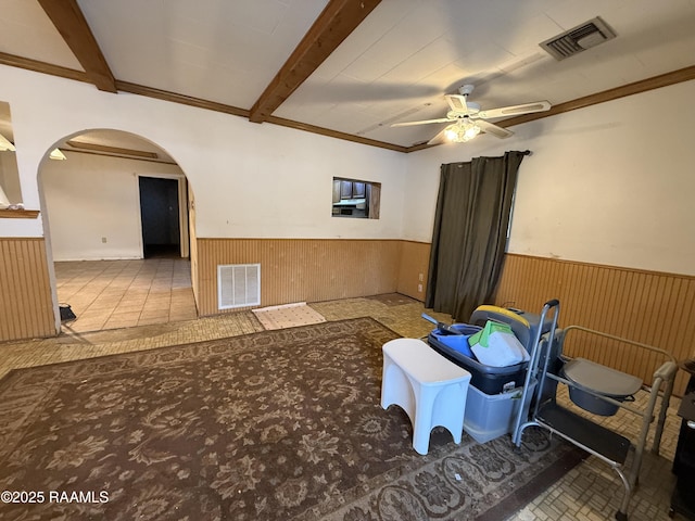 2015 Cummings St, Opelousas, LA 70570 - empty room with arched walkways, wainscoting, ceiling fan, beamed ceiling, and wood walls