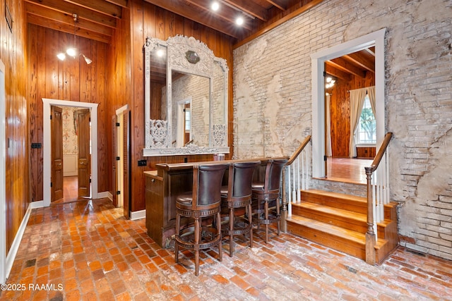 1414 E Bayou Pkwy, Lafayette, LA 70508 - indoor dry bar with a high ceiling, brick floors, wood walls, stairway, and wooden ceiling