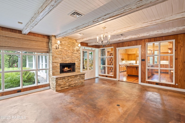 1414 E Bayou Pkwy, Lafayette, LA 70508 - unfurnished living room featuring concrete flooring, beamed ceiling, a chandelier, wood walls, and a fireplace