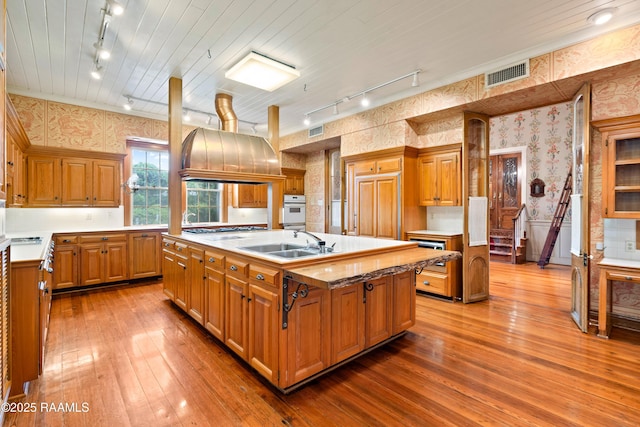 1414 E Bayou Pkwy, Lafayette, LA 70508 - kitchen featuring track lighting, wallpapered walls, a sink, oven, and wood-type flooring