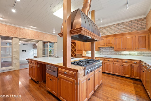 1414 E Bayou Pkwy, Lafayette, LA 70508 - kitchen with stainless steel gas cooktop, tile counters, light wood-style floors, track lighting, and crown molding