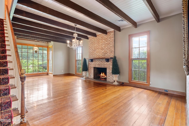 1414 E Bayou Pkwy, Lafayette, LA 70508 - unfurnished living room featuring a chandelier, beamed ceiling, hardwood / wood-style floors, stairway, and baseboards