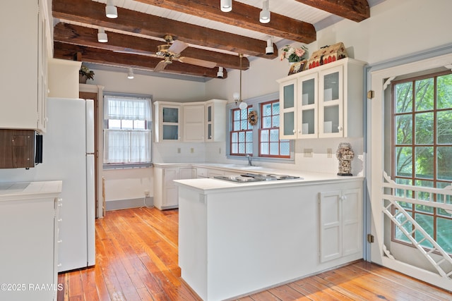 1414 E Bayou Pkwy, Lafayette, LA 70508 - kitchen with a peninsula, a sink, healthy amount of natural light, light wood-type flooring, and beamed ceiling