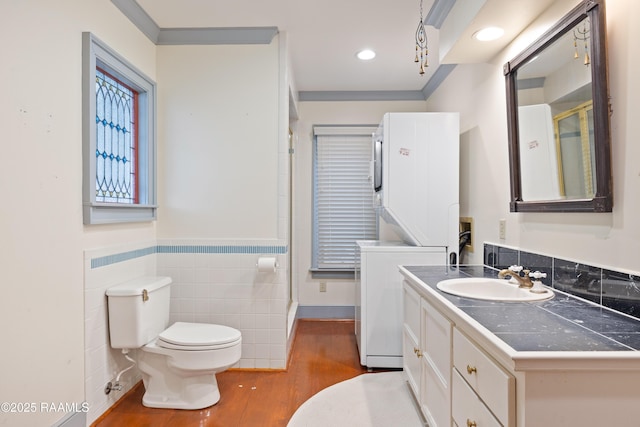 1414 E Bayou Pkwy, Lafayette, LA 70508 - full bathroom featuring vanity, toilet, a wainscoted wall, wood finished floors, and tile walls