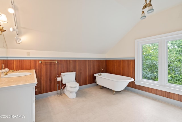 1414 E Bayou Pkwy, Lafayette, LA 70508 - bathroom with lofted ceiling, a freestanding bath, toilet, vanity, and a wainscoted wall