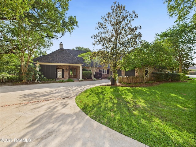105 Oak Aly, Lafayette, LA 70508 - view of front facade with curved driveway, a front lawn, brick siding, and a chimney