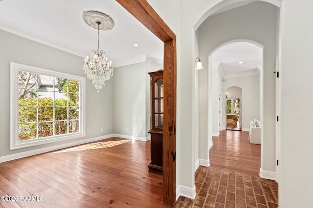 105 Oak Aly, Lafayette, LA 70508 - foyer entrance featuring ornamental molding, arched walkways, baseboards, a chandelier, and dark wood finished floors